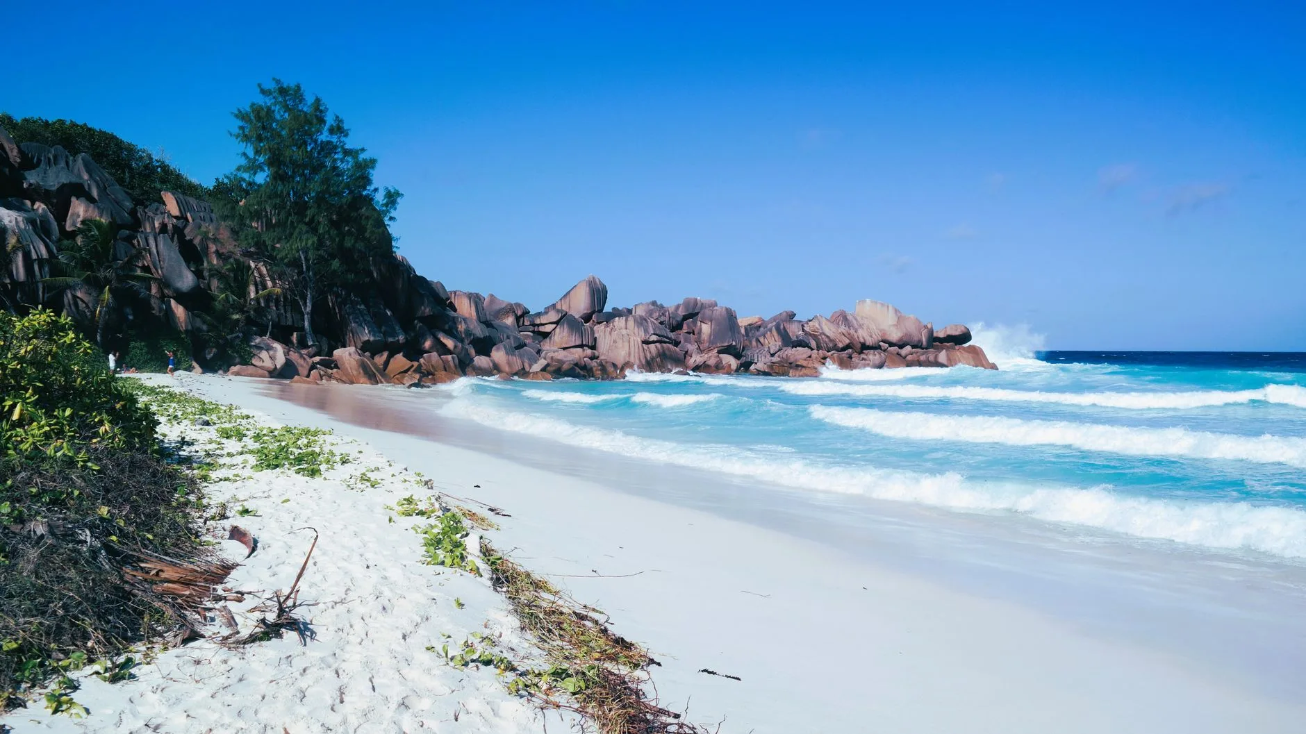 Turquoise waters lapping white sand beach flanked by granite boulders, Seychelles