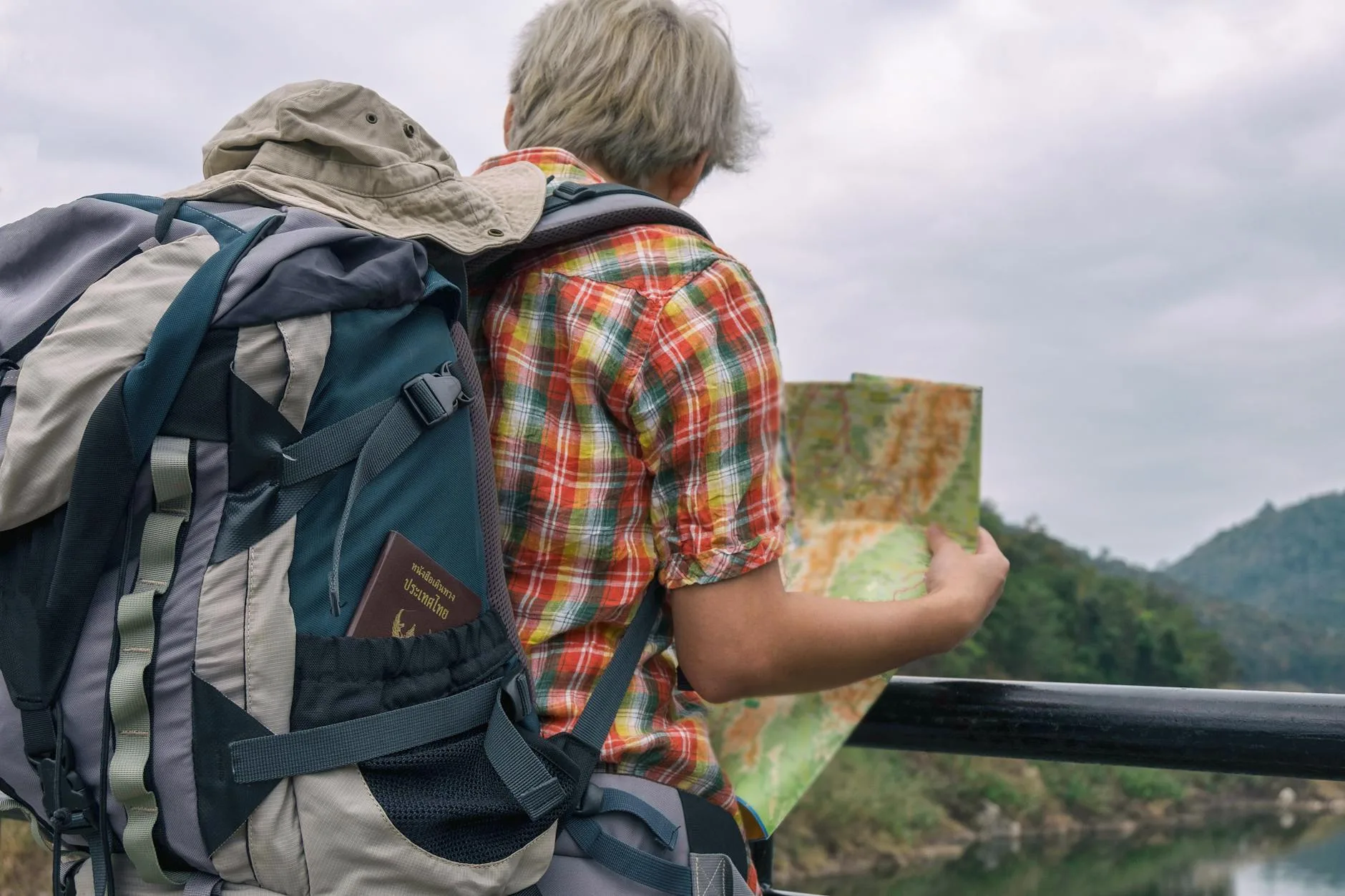 Solo traveler with backpack gazing at a scenic mountain vista at golden hour