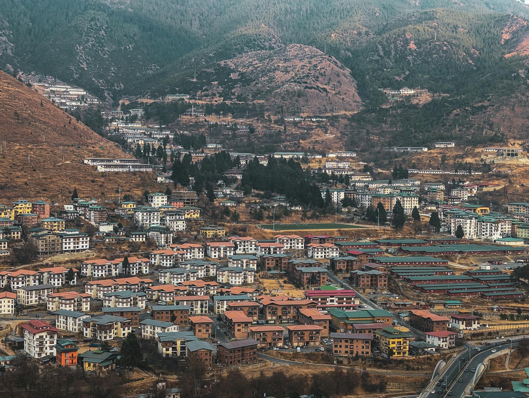Monastery perched on Bhutan's misty cliffside, framed by prayer flags and pine trees