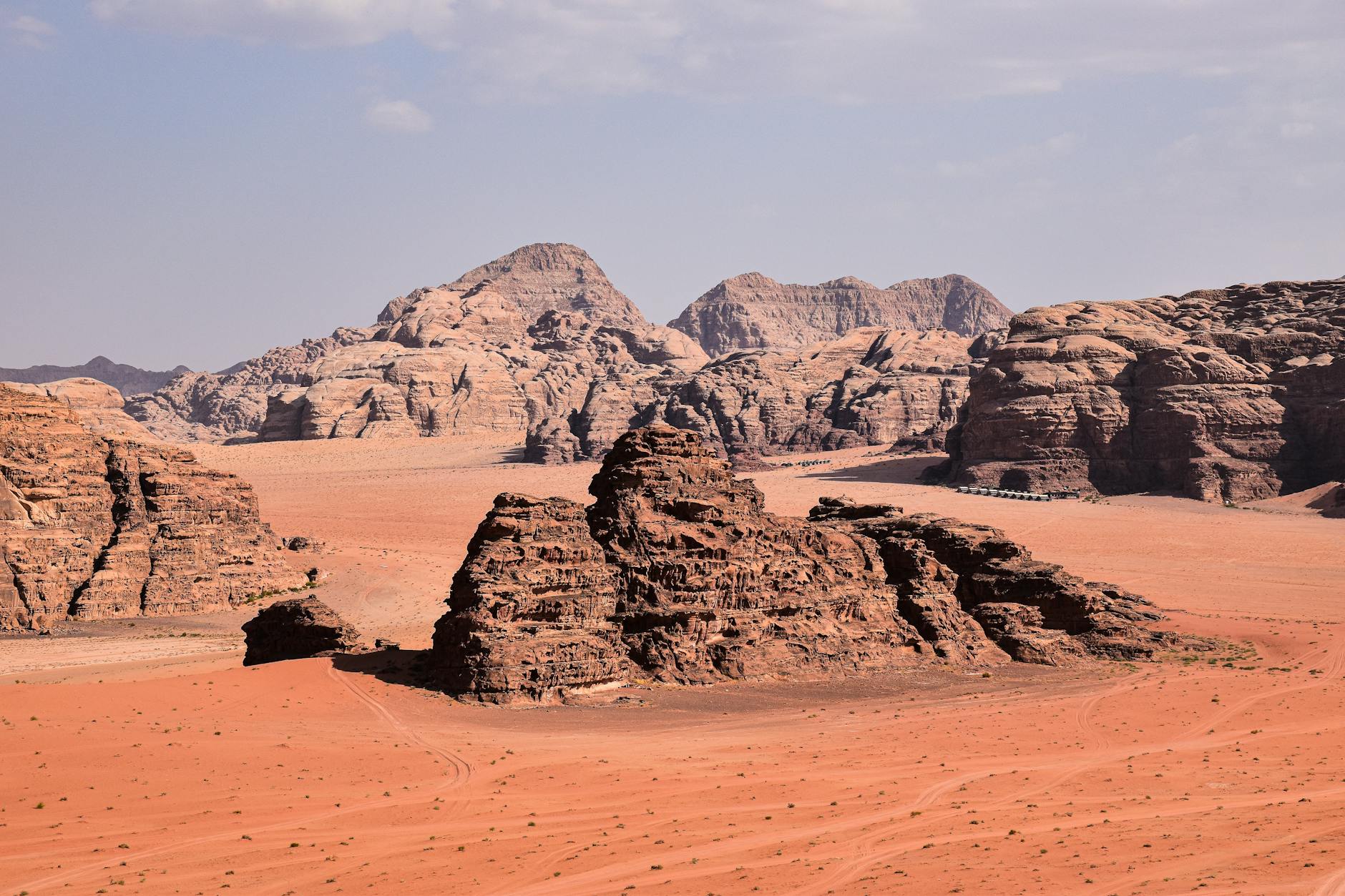 Woman exploring ancient Petra ruins alone, warm golden sandstone cliffs towering overhead