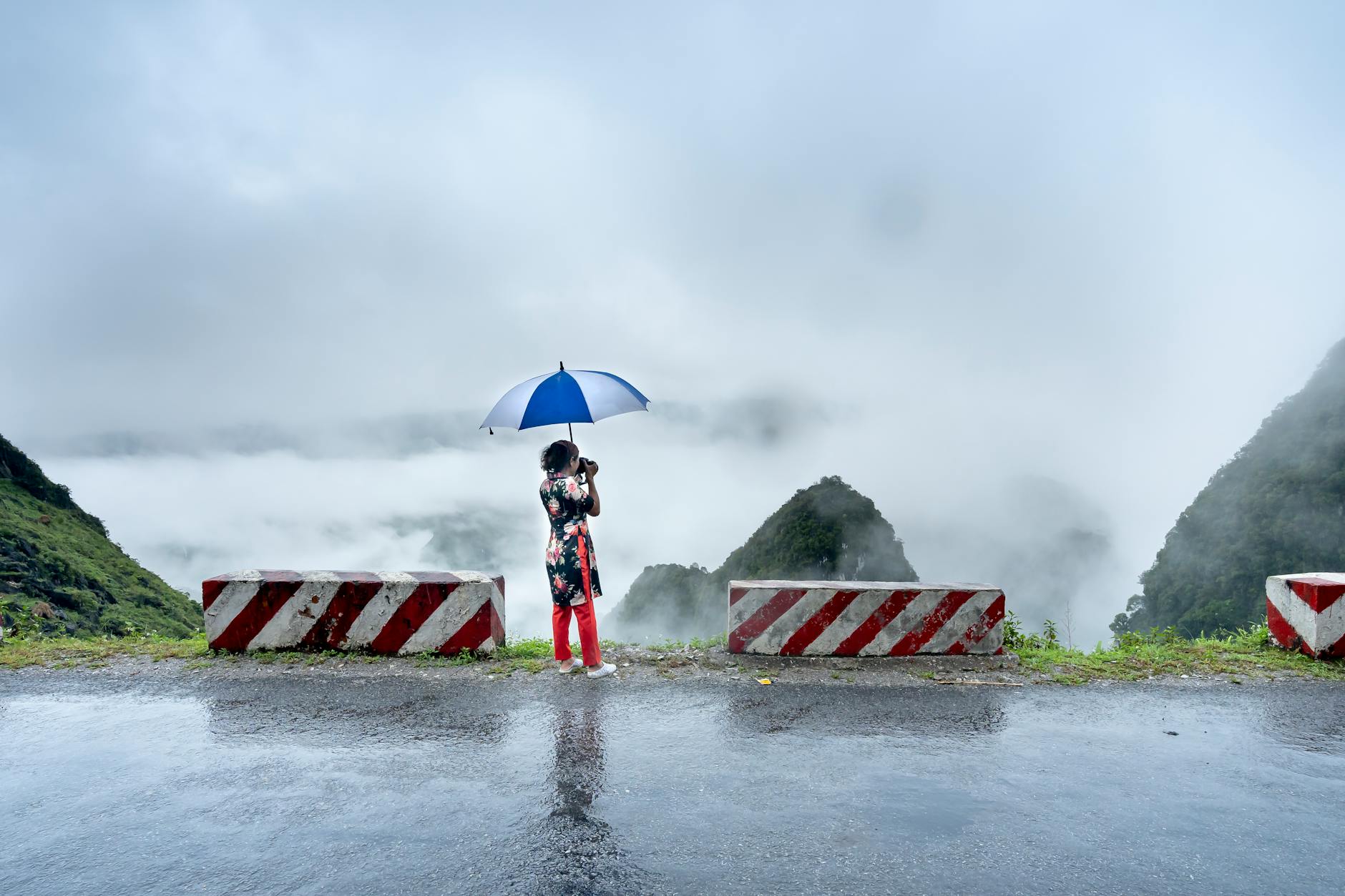 Lone traveler with backpack gazing at misty mountain path at dawn