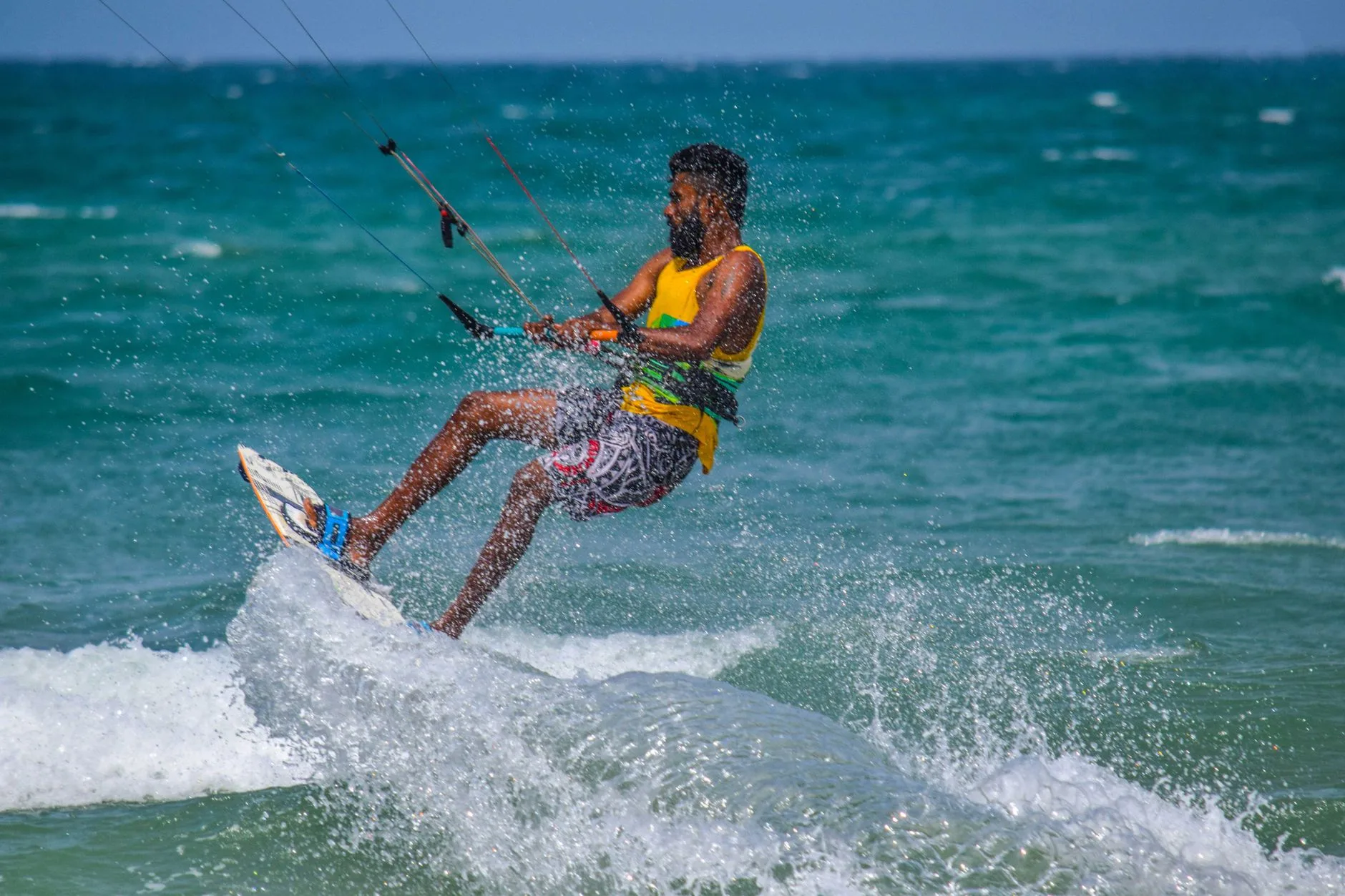 Beginner surfer riding a gentle wave on a sunny Sri Lanka beach