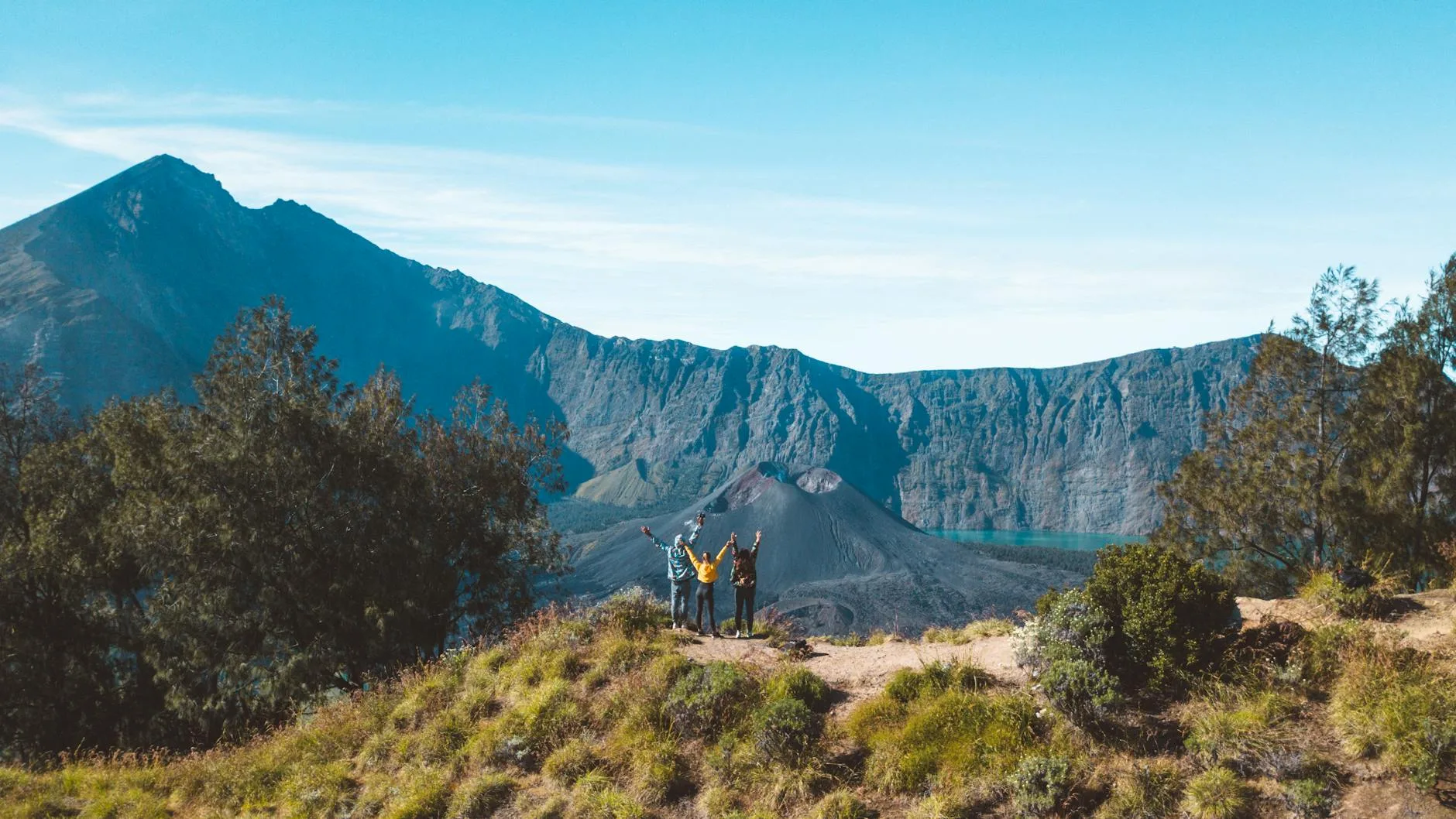 Hiker silhouetted against glowing crater at dawn on an Indonesian volcano