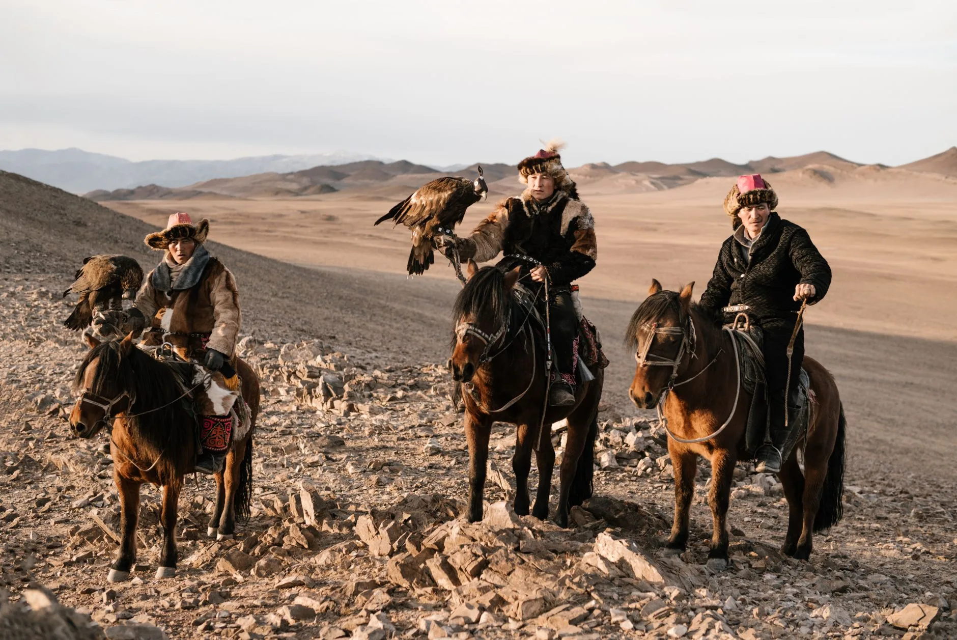 Lone traveler on a dusty Silk Road path beneath vast Central Asian mountains