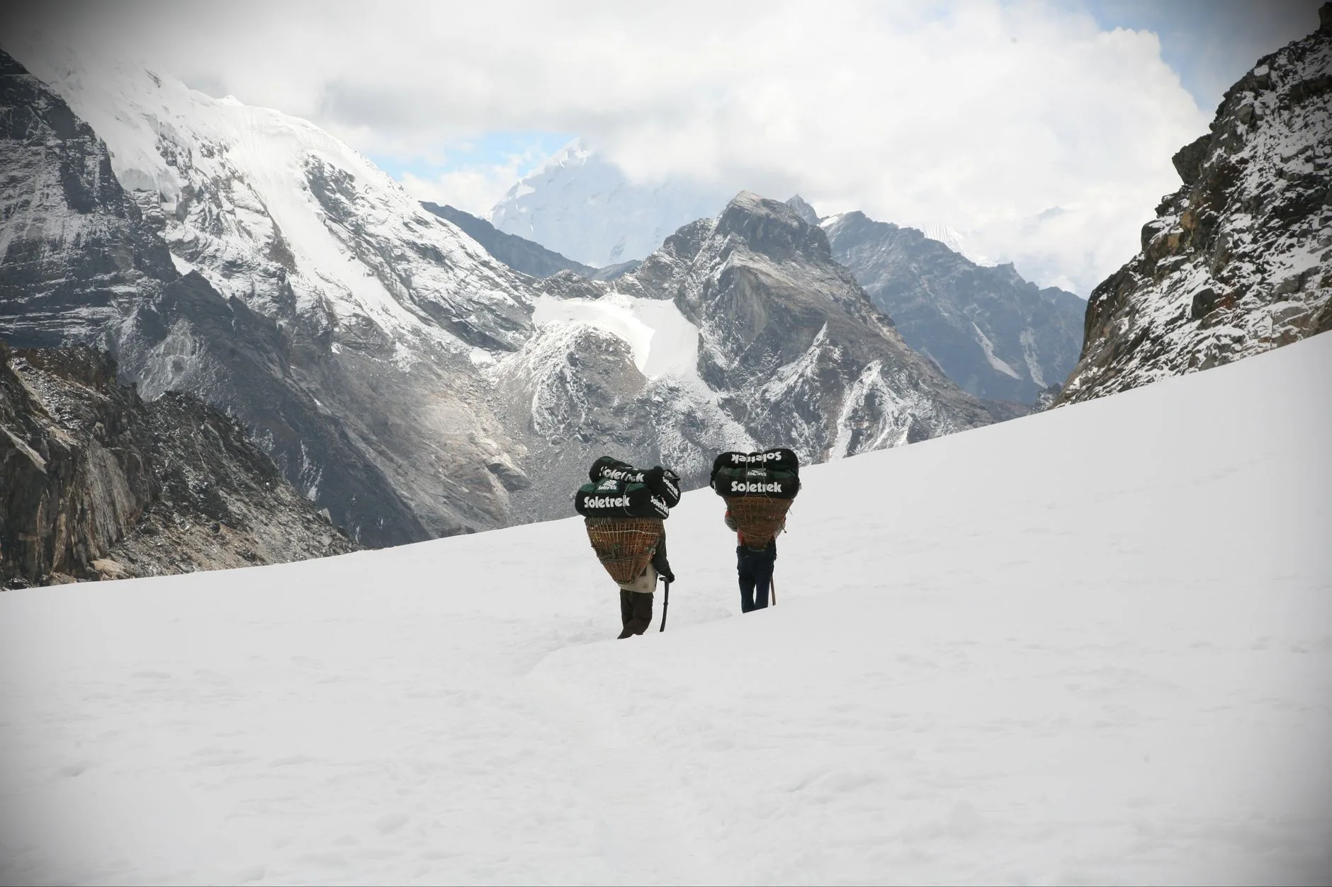 Trekker on a misty Himalayan trail surrounded by snow-capped peaks in Nepal