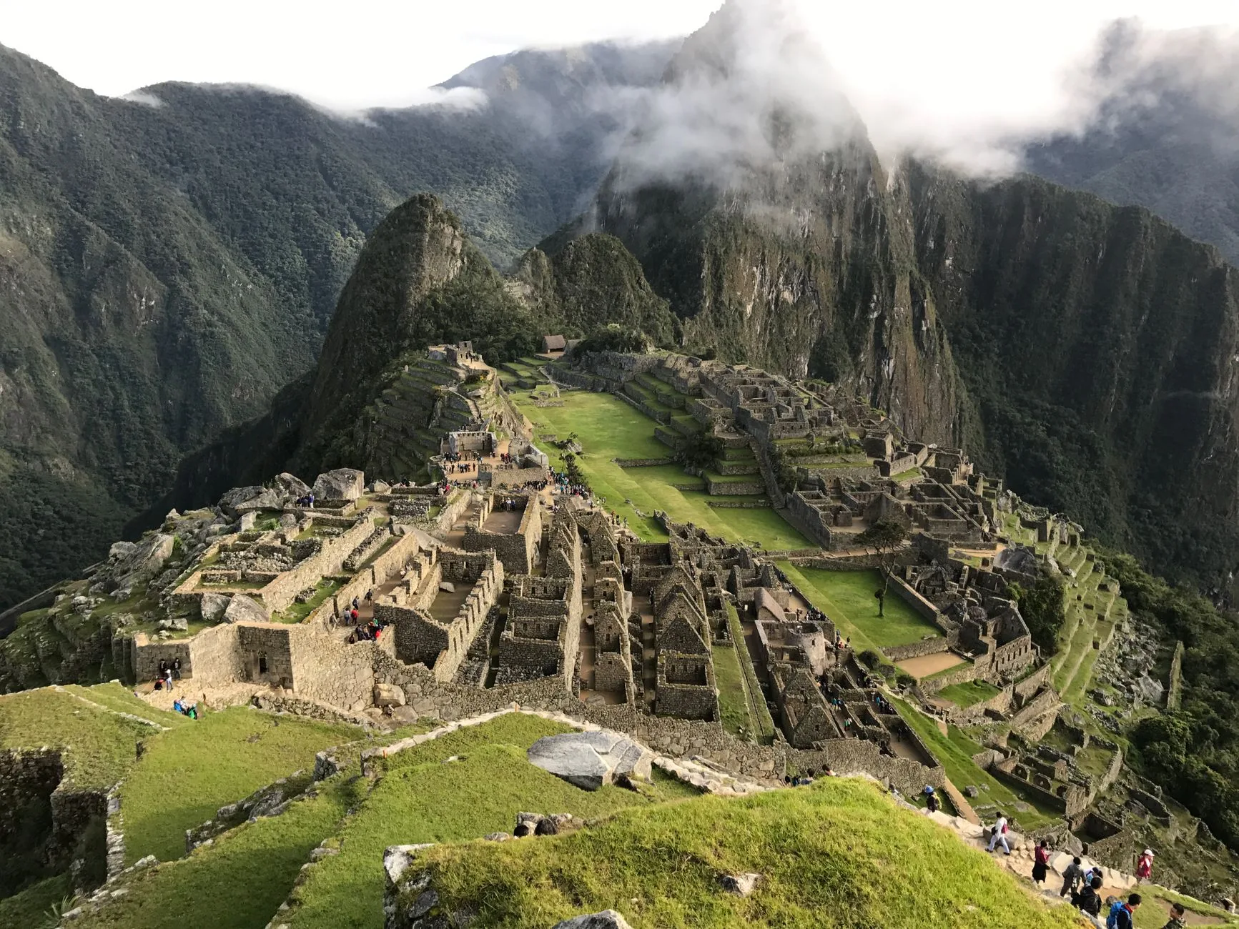 Ancient stone terraces of Machu Picchu emerge from misty Andean peaks at sunrise
