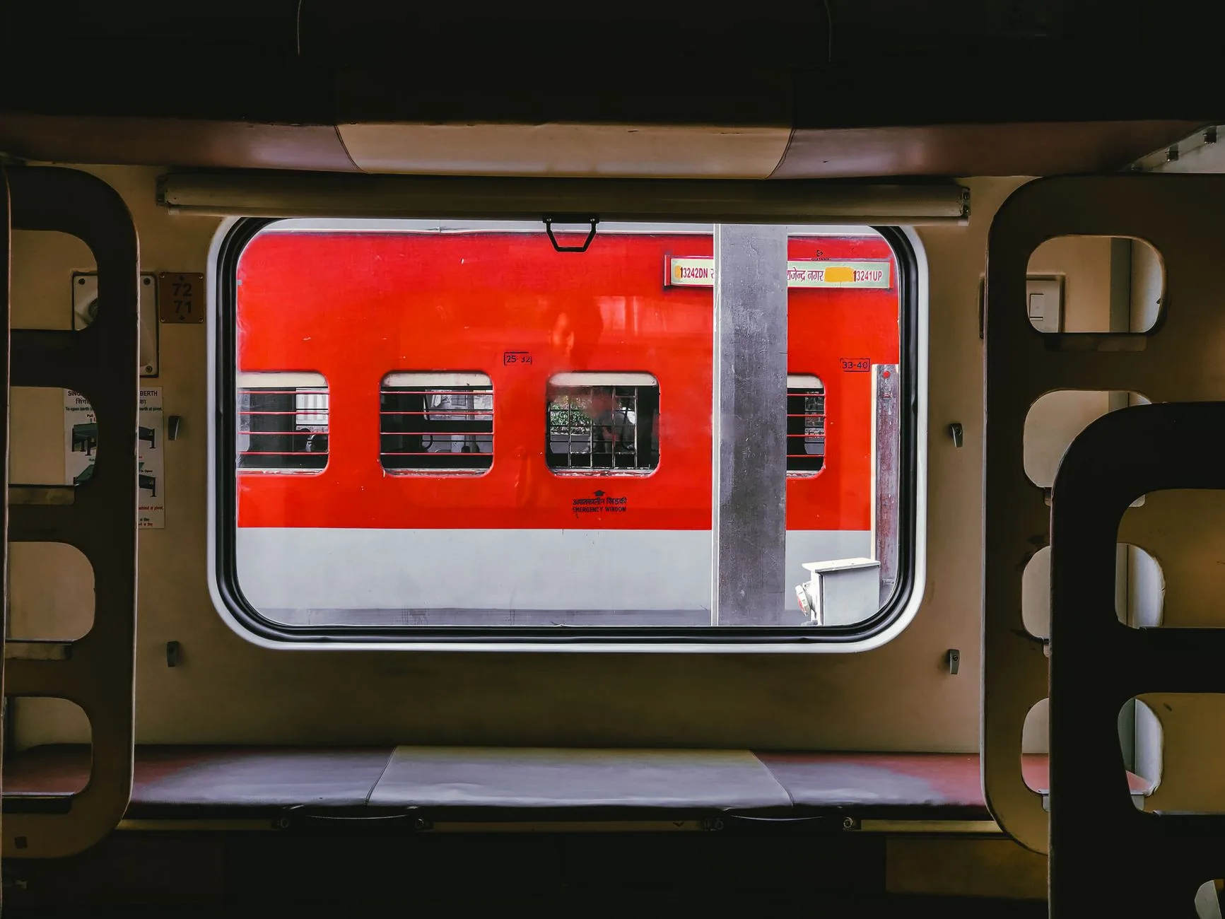 Colorful Indian passenger train winding through countryside at golden hour