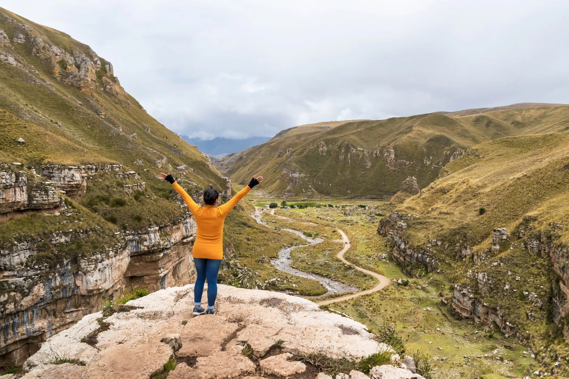 Woman traveler with backpack overlooking Andes mountains at sunrise, map in hand