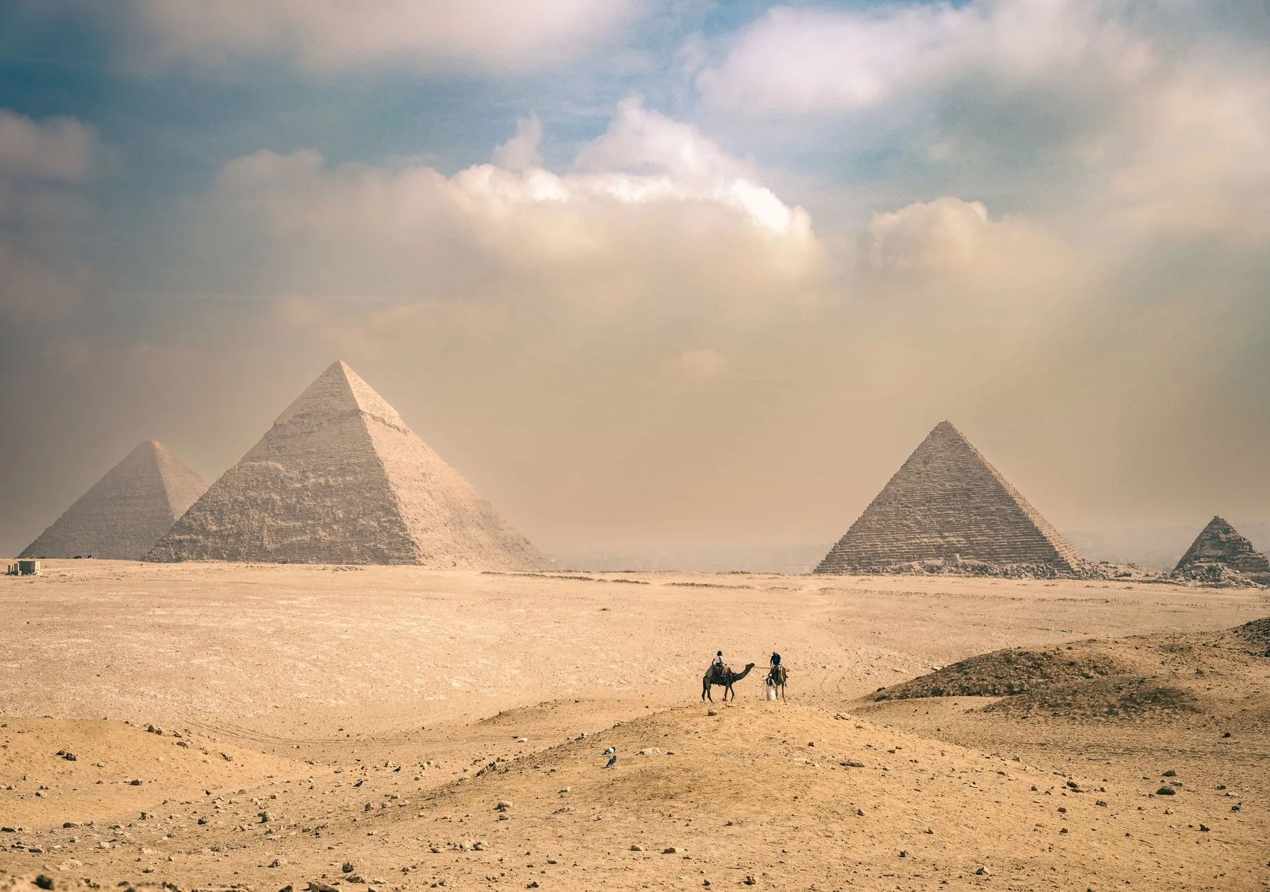 Sunlit Egyptian street market with spice stalls, lanterns, and locals beyond tourist crowds