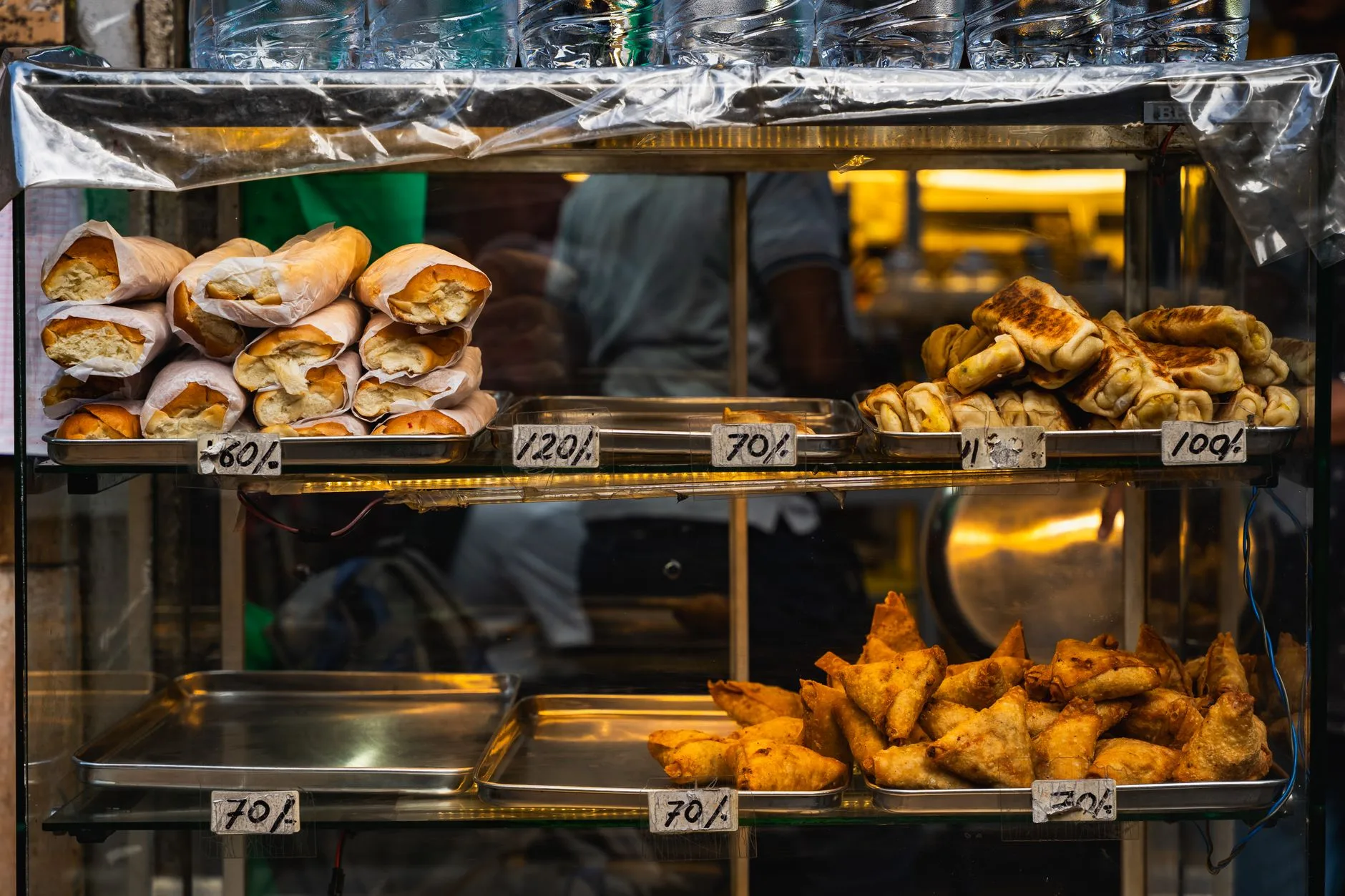 Street food vendor serving fresh local dishes at a bustling outdoor market stall