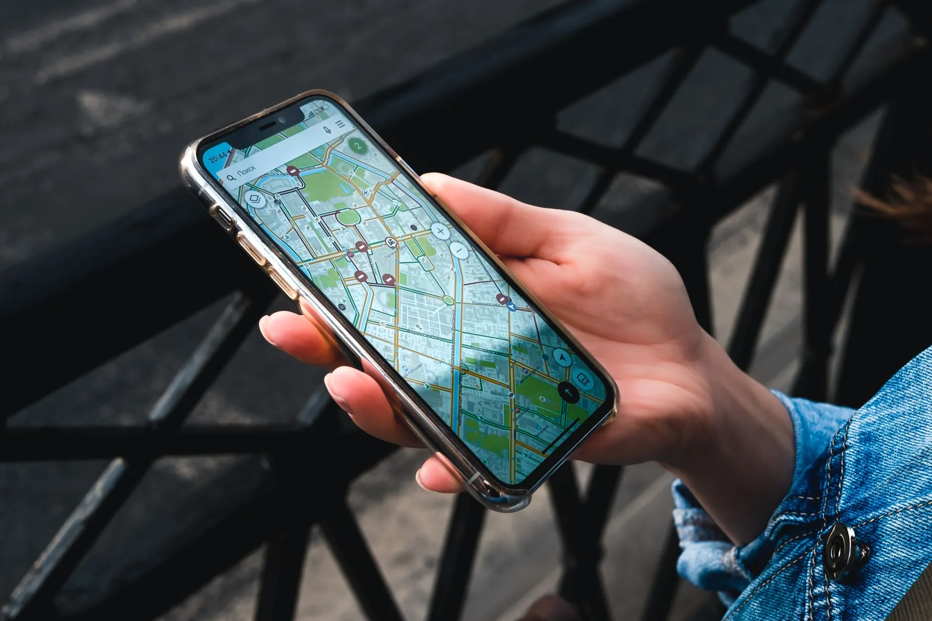 Traveler consulting a paper map and compass at a train station, phone-free journey