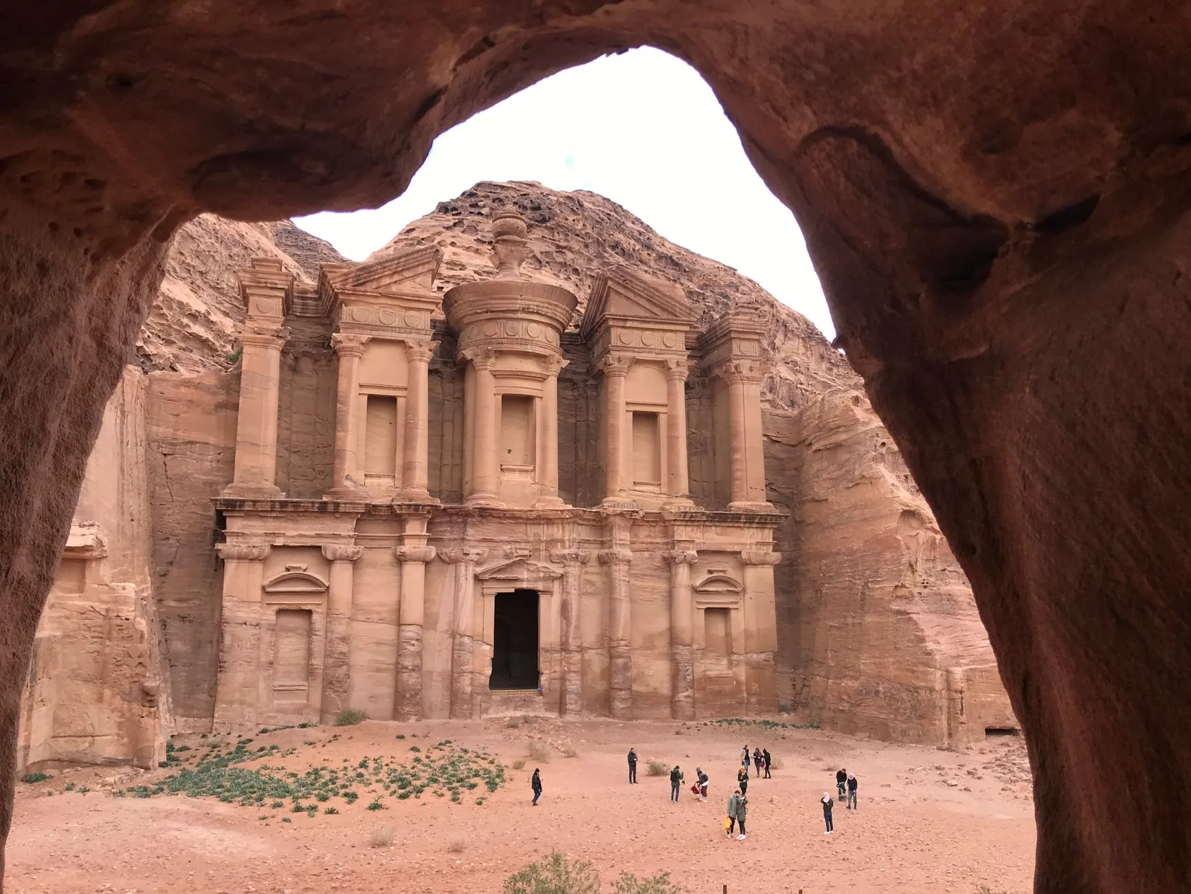 Treasury facade carved into pink sandstone cliffs at Petra, Jordan, lit by sunlight